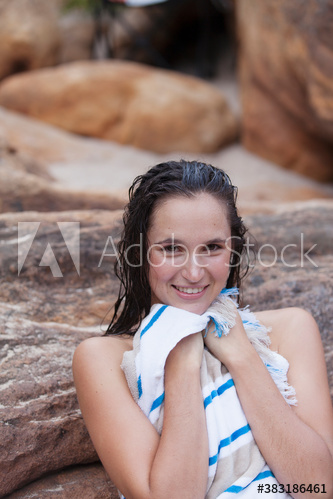 Portrait smiling young woman with wet hair drying off with towel