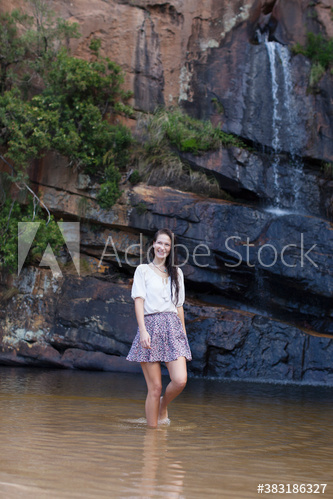 Portrait young woman in skirt wading in water