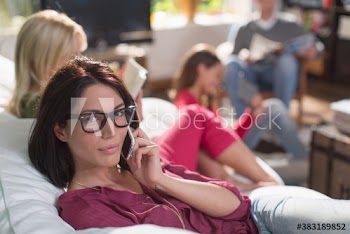 Portrait young woman talking on smart phone on sofa