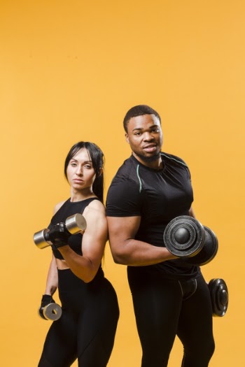 Posing athletes holding weights Free Photo