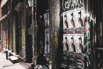 Posters on Wall Beside of Sidewalk