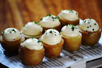 Potatoes on White Newspaper Near Brown Wooden Surface
