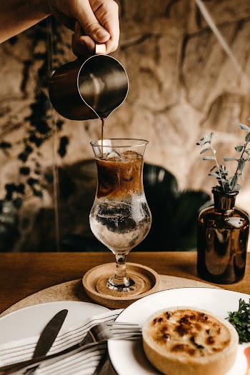 Pouring Coffee on Glass Cup