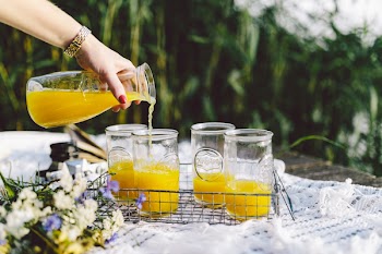 Pouring orange juice on picnic 