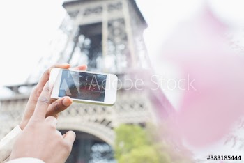 POV woman with camera phone below Eiffel Tower, Paris, France