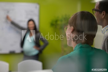Pregnant businesswoman leading meeting in conference room