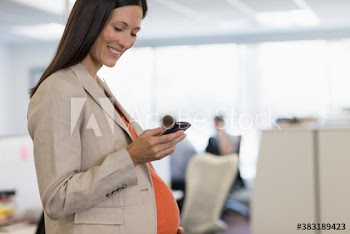 Pregnant businesswoman using smart phone in office