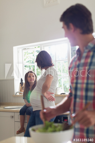 Pregnant mother talking to daughter in kitchen