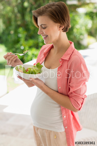 Pregnant woman eating healthy salad