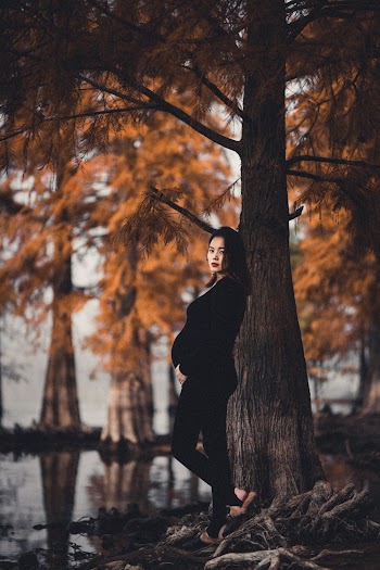 Pregnant Woman in Black Clothing Standing Next to Tree