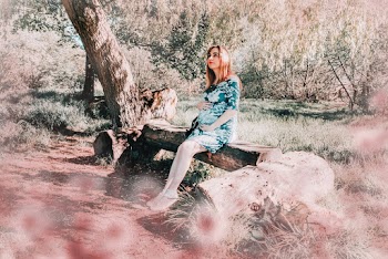 Pregnant Woman in Green and White Floral Dress Sitting on Wooden Bench