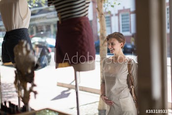 Pregnant woman window shopping outside shop
