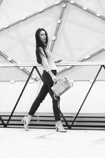 Pretty young model posing in jeans and shirt with yellow handbag.
