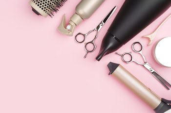 Professional hairdressing tools on pink background with copy space