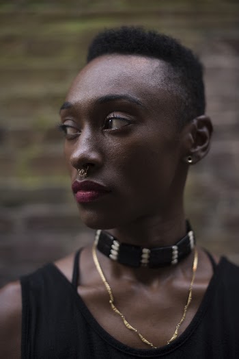 Profile Of A Person With Short Black Hair Wearing Black Sleeveless Top
