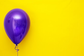 Purple Balloon against Yellow Background