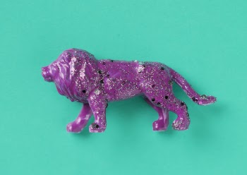 Purple Lion Ceramic Figurine on Green Surface