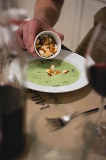 Putting croutons in a spinach soup 