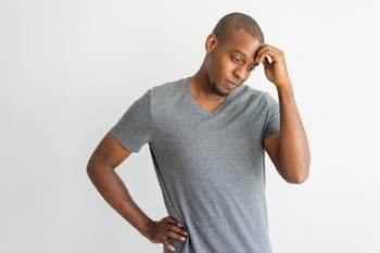 Puzzled handsome African man having problems. 