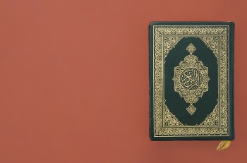 Quran on a plain burgundy background Free Photo