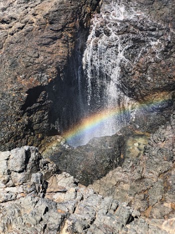 Rainbow Reflection on Water Flowing over Rock