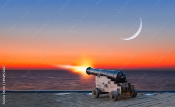 Ramadan Concept - Ramadan kareem cannon with crescent and fireworks - Night sky with moon in the clouds at sunset