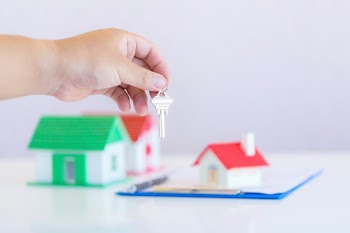 Real estate agent with house model and keys Free Photo