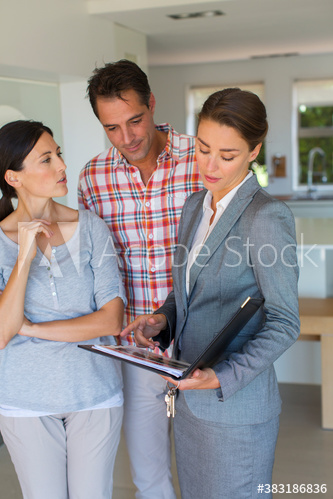 Realtor and couple talking in house