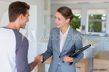 Realtor shaking hands with client in house