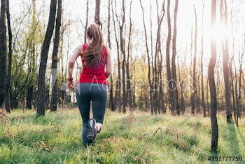 Rear view of young woman running outdoors