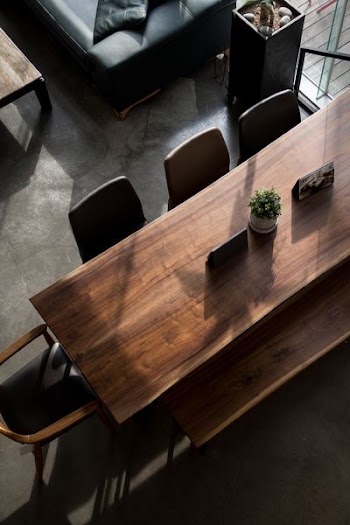 rectangular brown wooden table with white ceramic potted plant inside the room