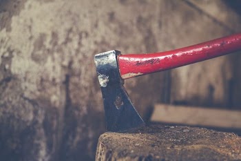 red and black axe on wood slab