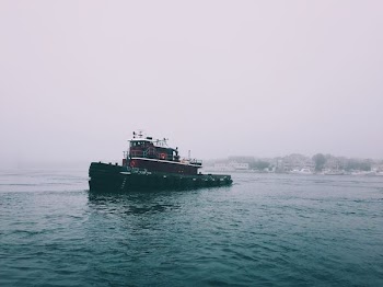 red and black boat on sea water