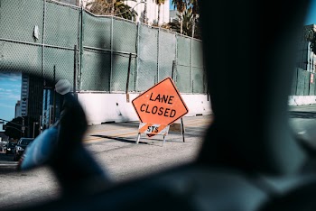 Red and Black Lane Closed Signage on Road