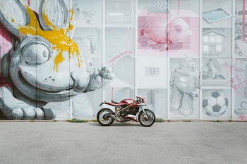 Red and Black Motorcycle Parked Near Wall