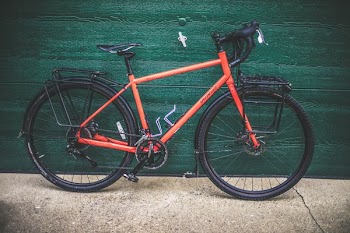 red and black road bike on green wall