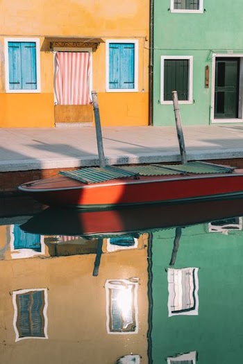 red and green boat docking on dock