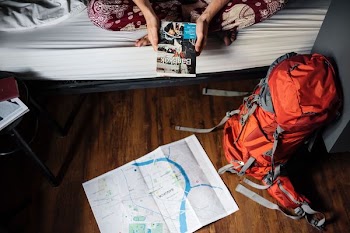 red and grey hiking backpack beside bed