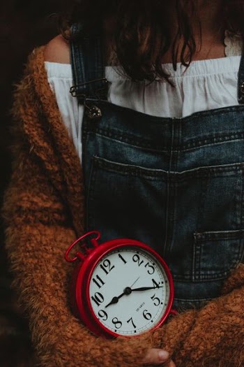 red and white analog clock showing 9:22