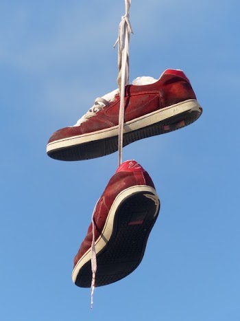 Red and White Hanging Sneakers during Daytime