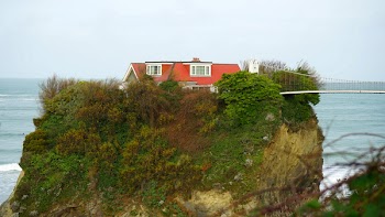 Red and White House on Top of Mountain Near Hanging Bridge
