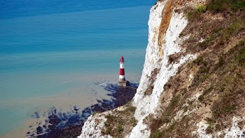 Red and White Lighthouse Near Body of Water