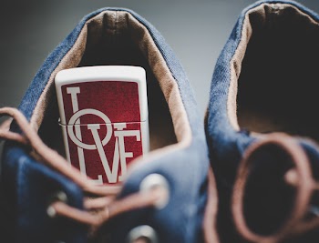 Red and White Love Flip Lighter in Shoe in Focus Photography