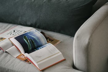 Red and White Reading Book on Gray Textile