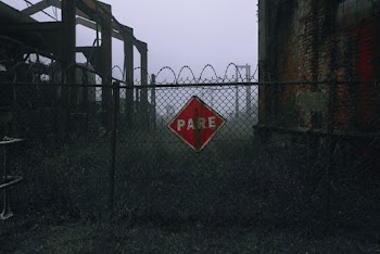 Red and White Stop Sign on Gray Metal Fence