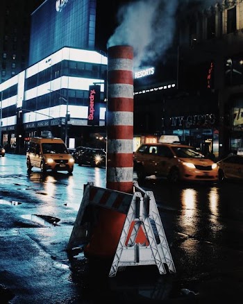 red and white striped pipe on blacktop road