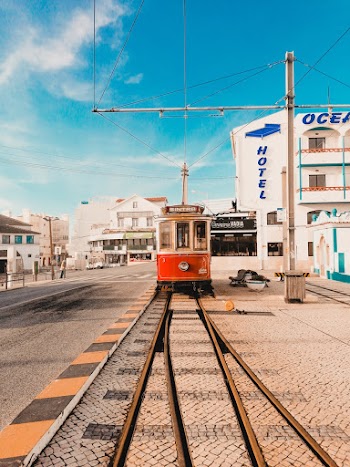Red and White Tram Near Ocean Hotel Under Blue and White Sky