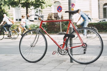 Red Bike Parked Beside Post