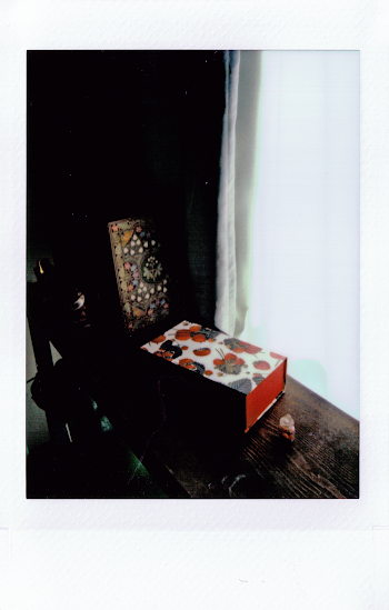 Red, Black and White Box on Brown Panel