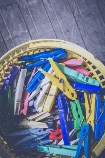 Red Blue Teal Green and Yellow Clothes Pin in Yellow Plastic Bucket